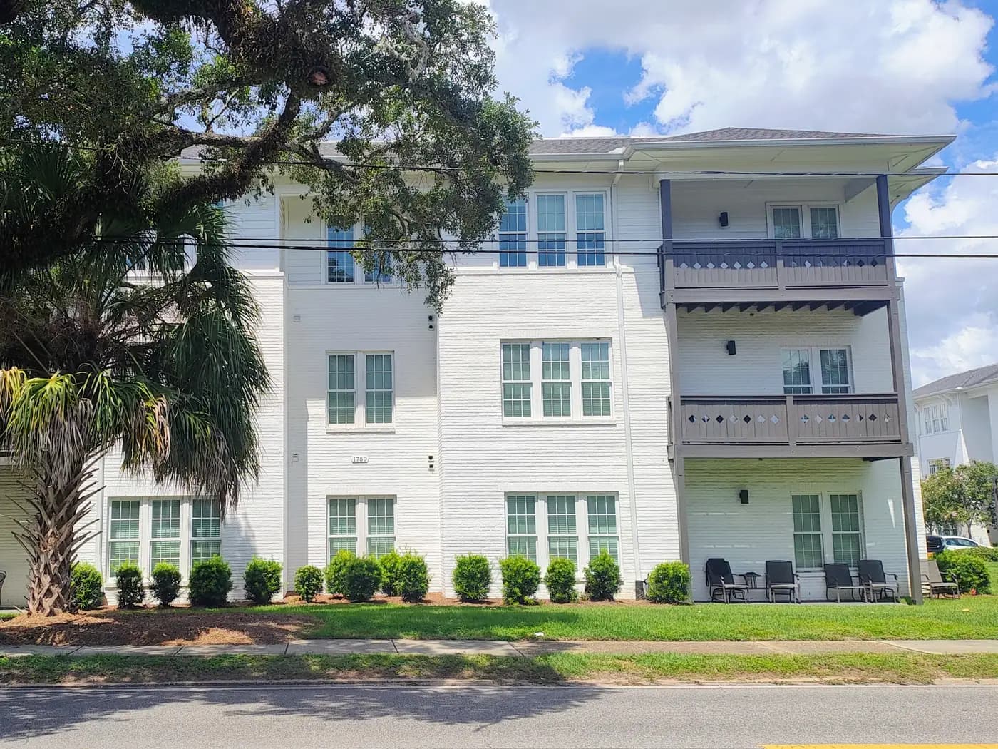 White brick residences and palms at Old Shell Lofts