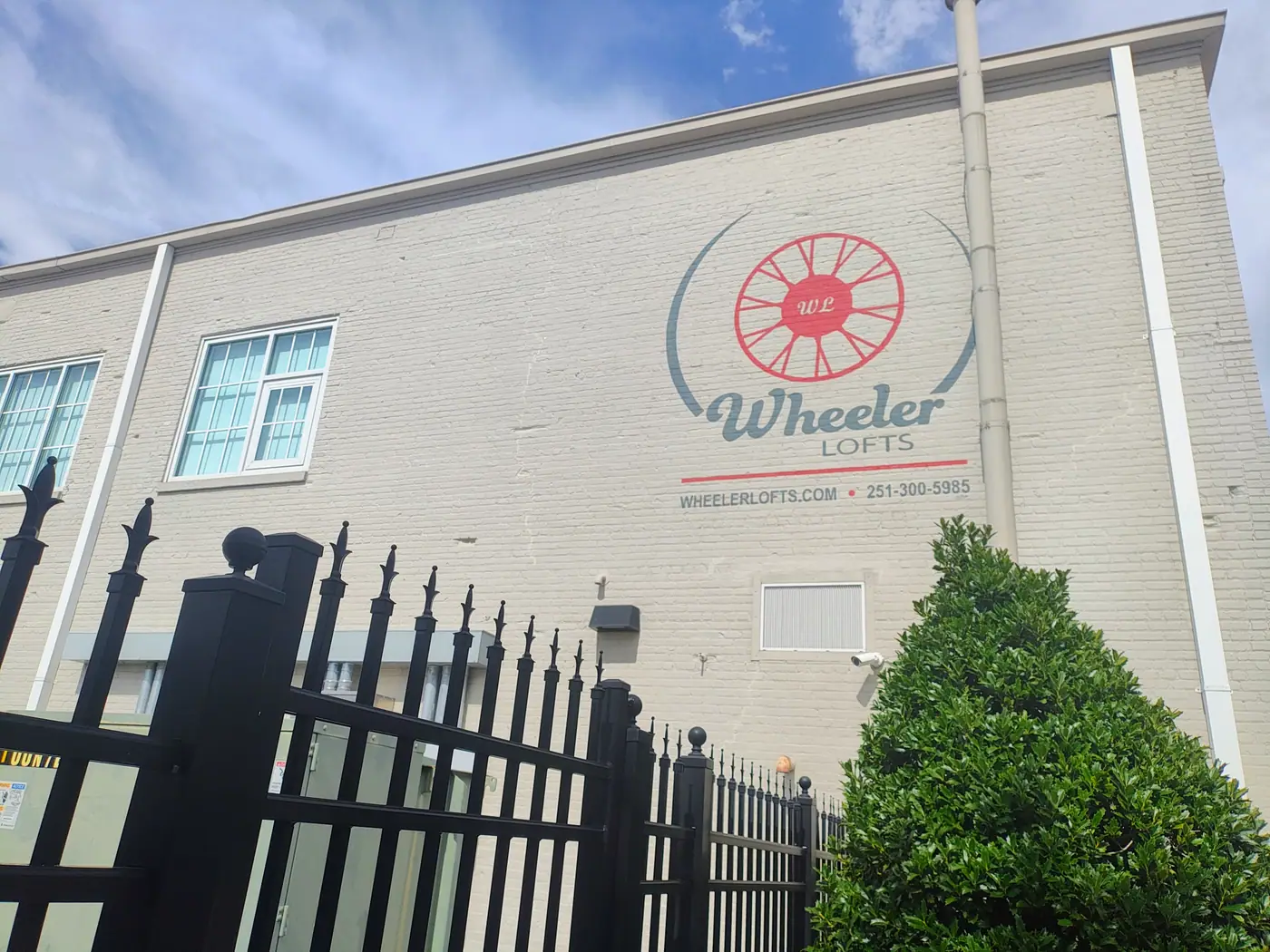 Wheeler Lofts logo on the brick exterior behind the gated lot